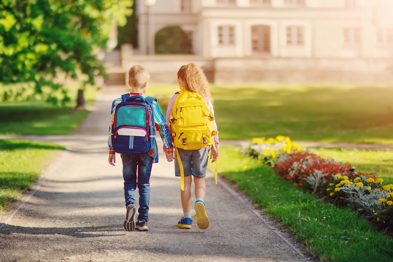Zeit & Raum für Sie und Ihr Kind - Erzieherin und Heilpädagogin - Mädchen und Junge gehen Händchen haltend zur Schule, um dort zu lernen.